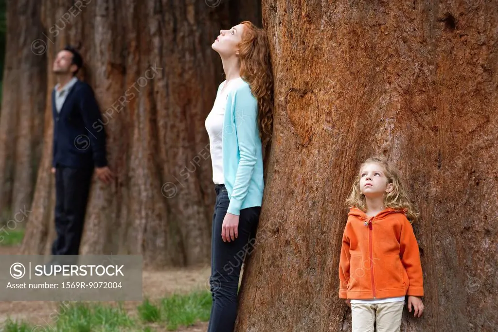 Mother and daughter leaning against tree trunk, breathing fresh air