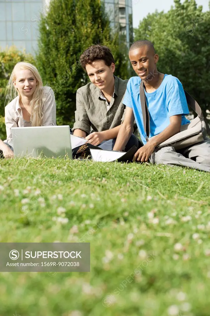 University students studying together on grass, low angle view
