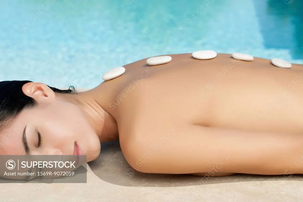 Woman enjoying lastone therapy beside pool