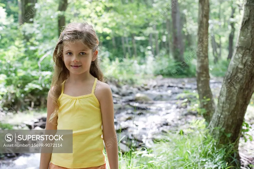 Girl by stream in woods, portrait