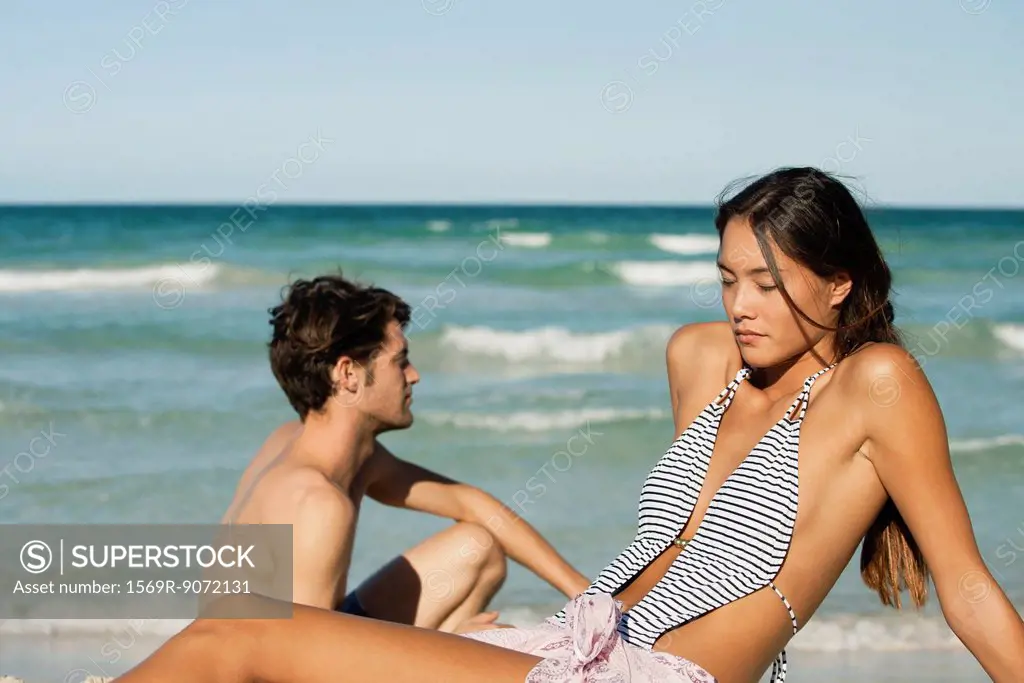 Young woman relaxing on beach with boyfriend