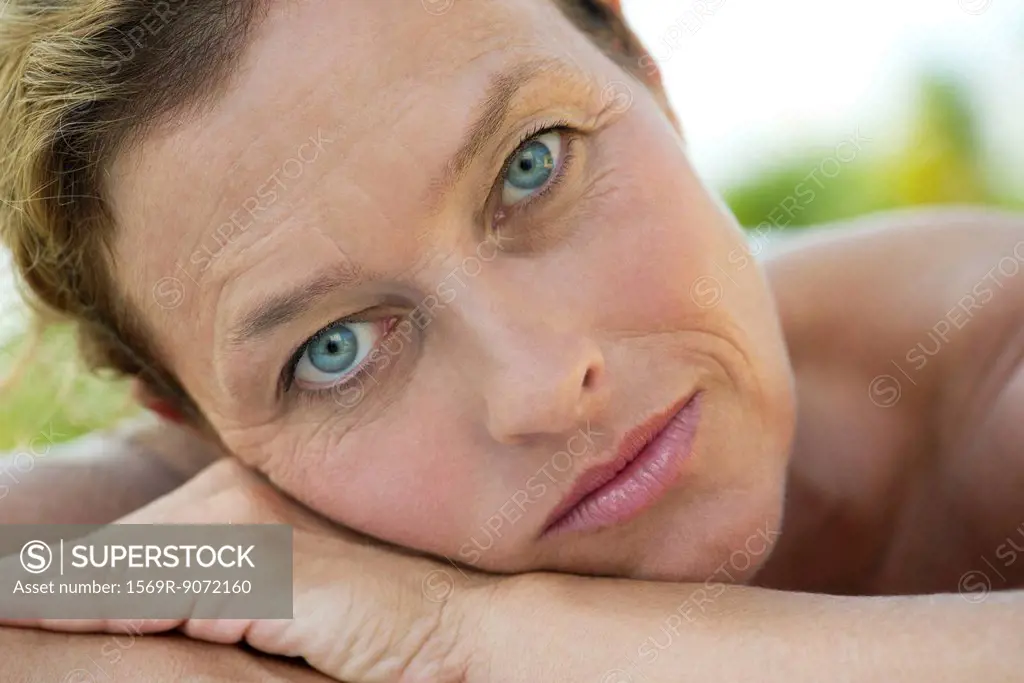 Mature woman resting head on arms, portrait