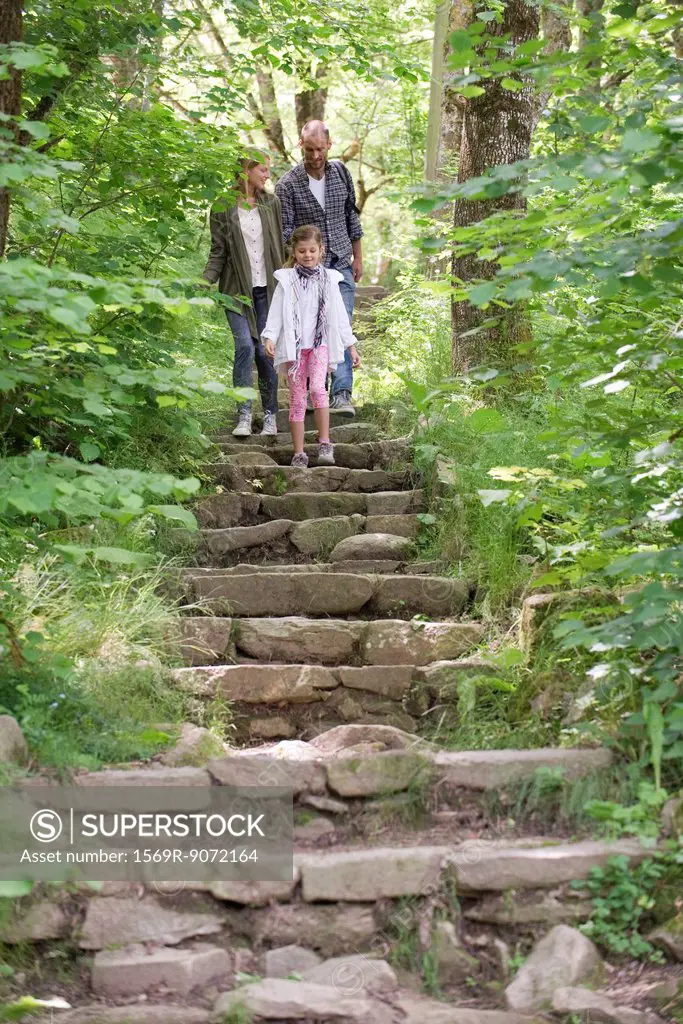 Family walking down stone steps in woods
