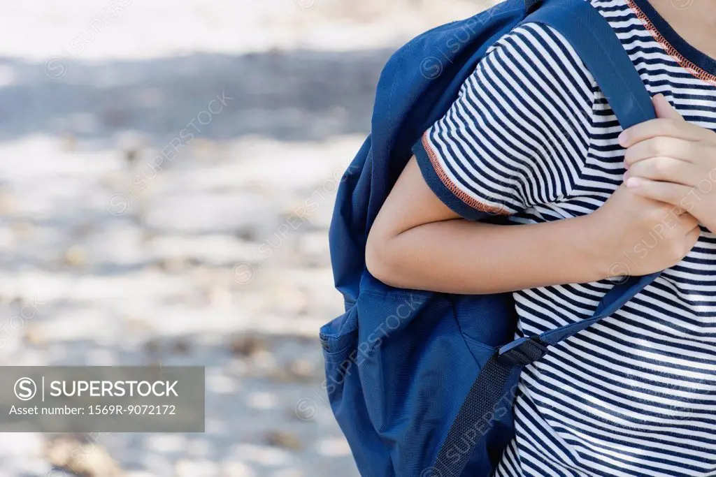 Boy carrying backpack, cropped