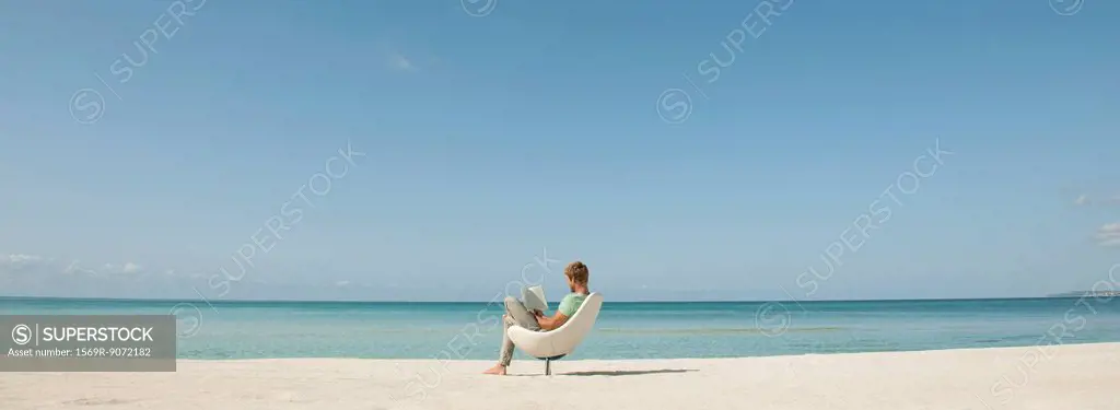Man reading book at the beach
