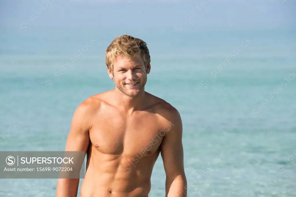 Barechested young man in water, portrait