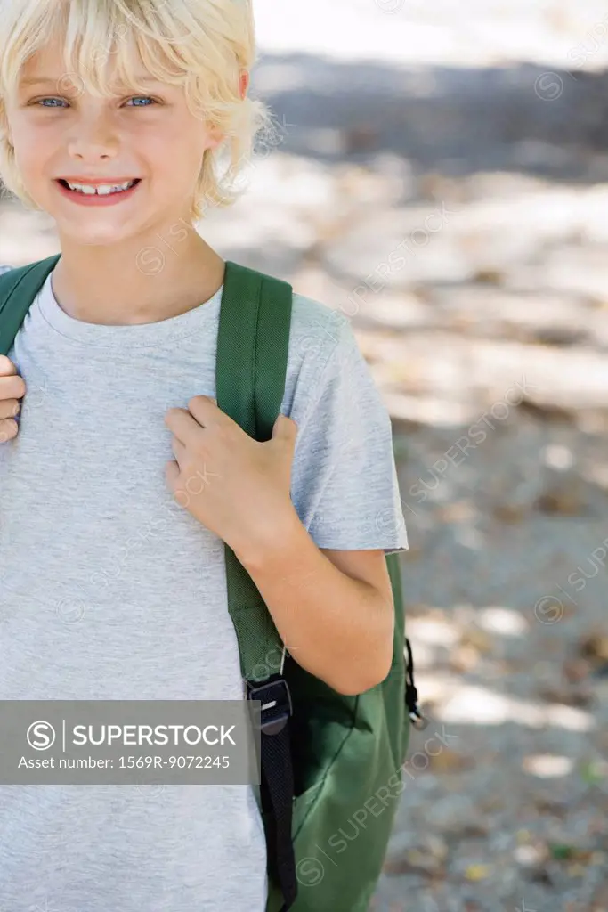 Boy carrying backpack, portrait