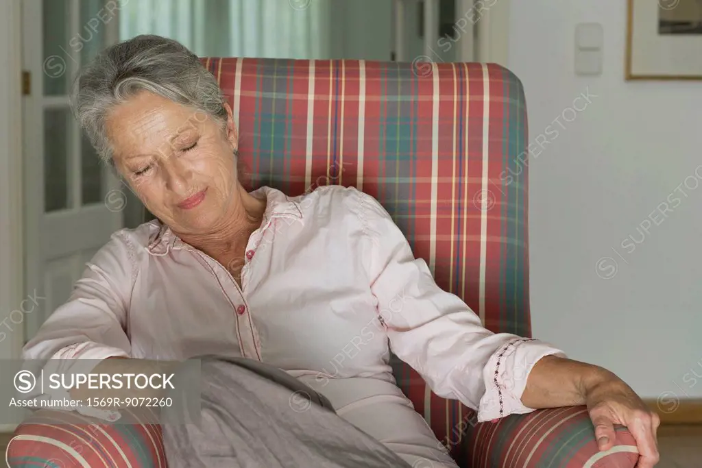Senior woman napping in armchair