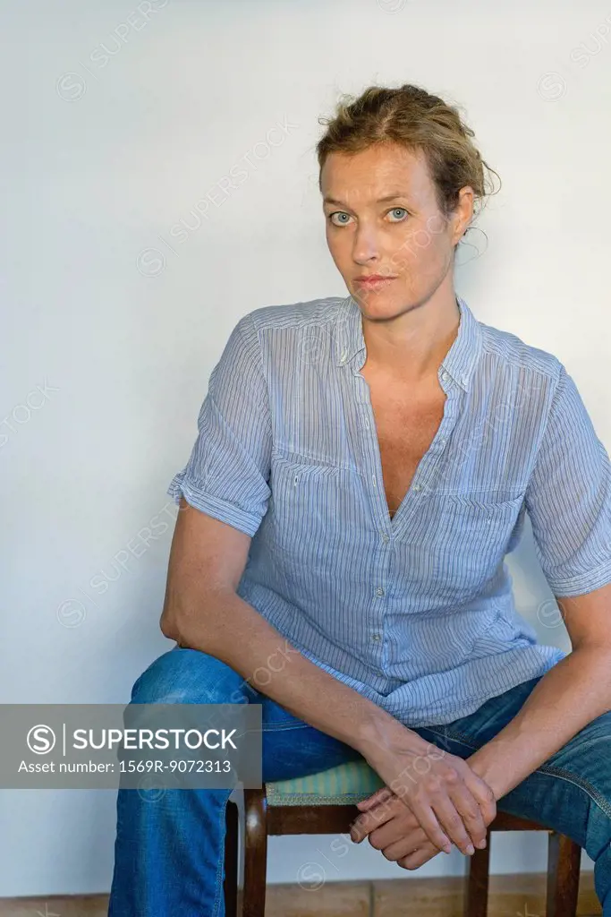 Mature woman sitting in chair, portrait
