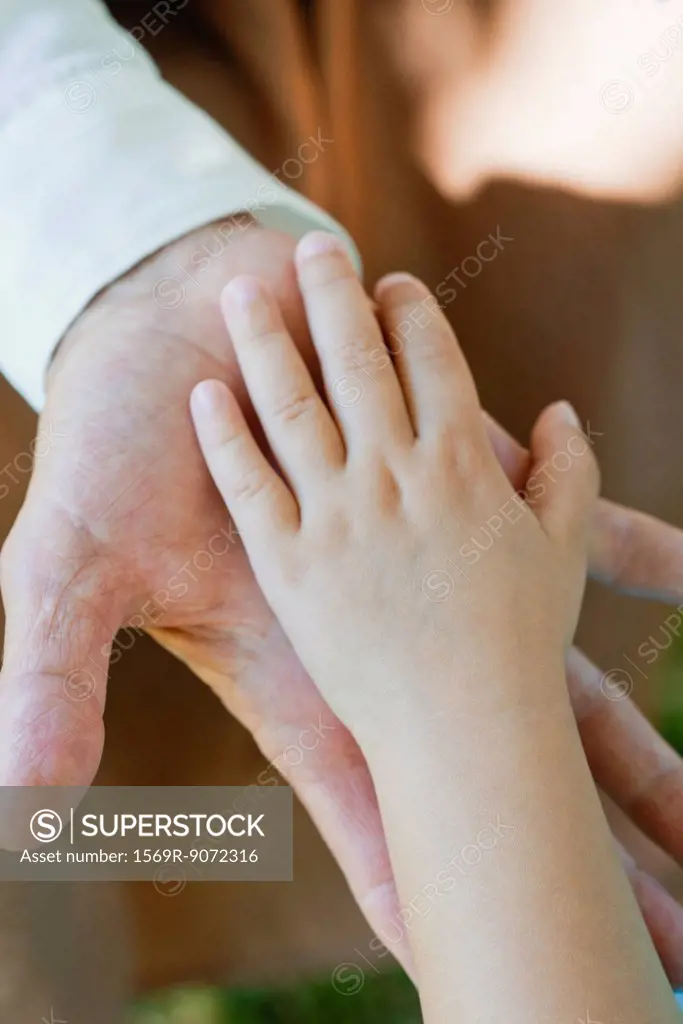 Little girl and grandmother´s hands touching