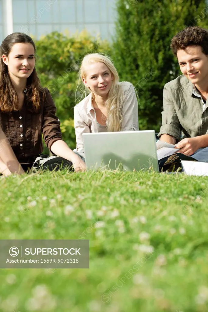 University students studying together on grass, low angle view