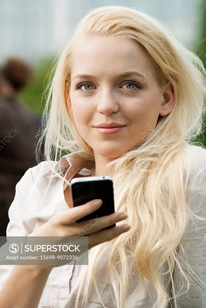 Young woman using cell phone, portrait