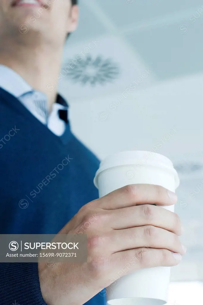 Man holding disposable coffee cup, cropped