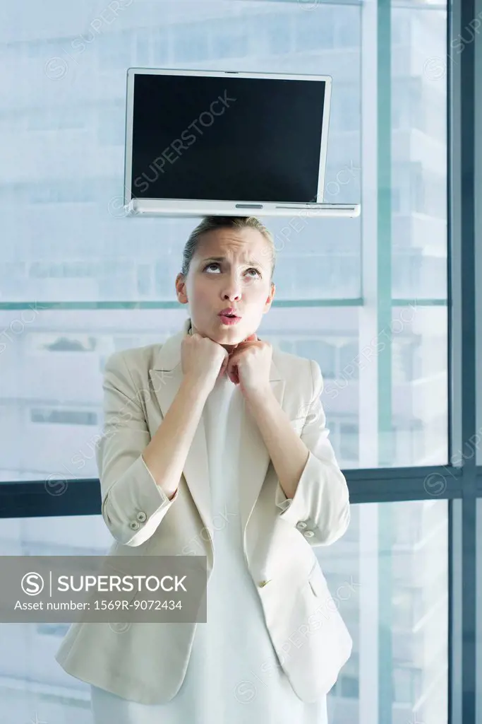Businesswoman with laptop computer on head