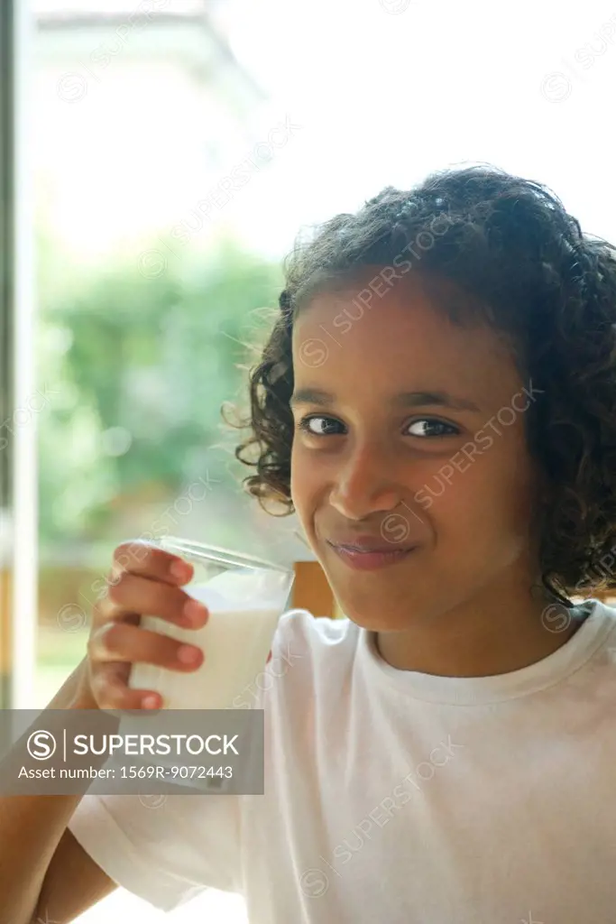 Girl drinking glass of milk, portrait