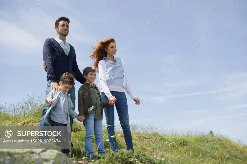 Parents and young boys standing on meadow, portrait