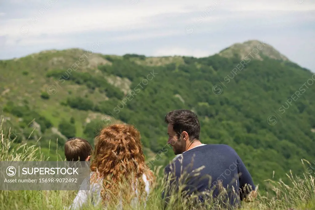 Young family looking at mountain view, rear view