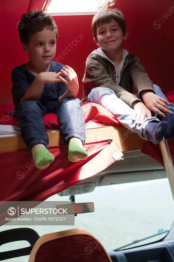 Young boys sitting on bed in motor home