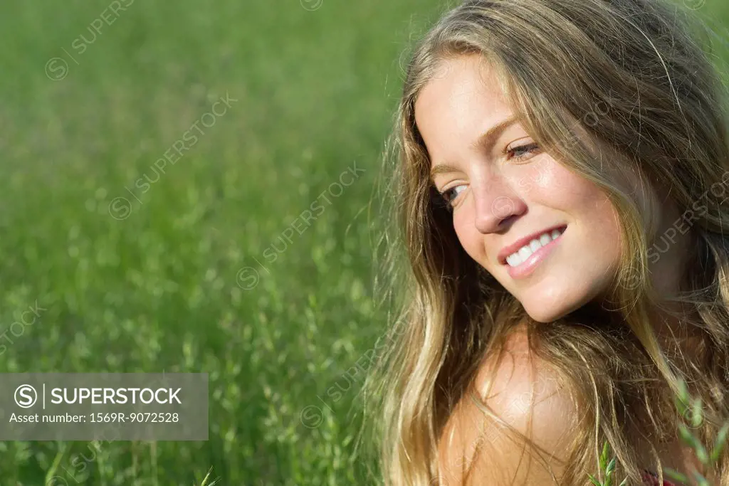 Young woman daydreaming outdoors, portrait