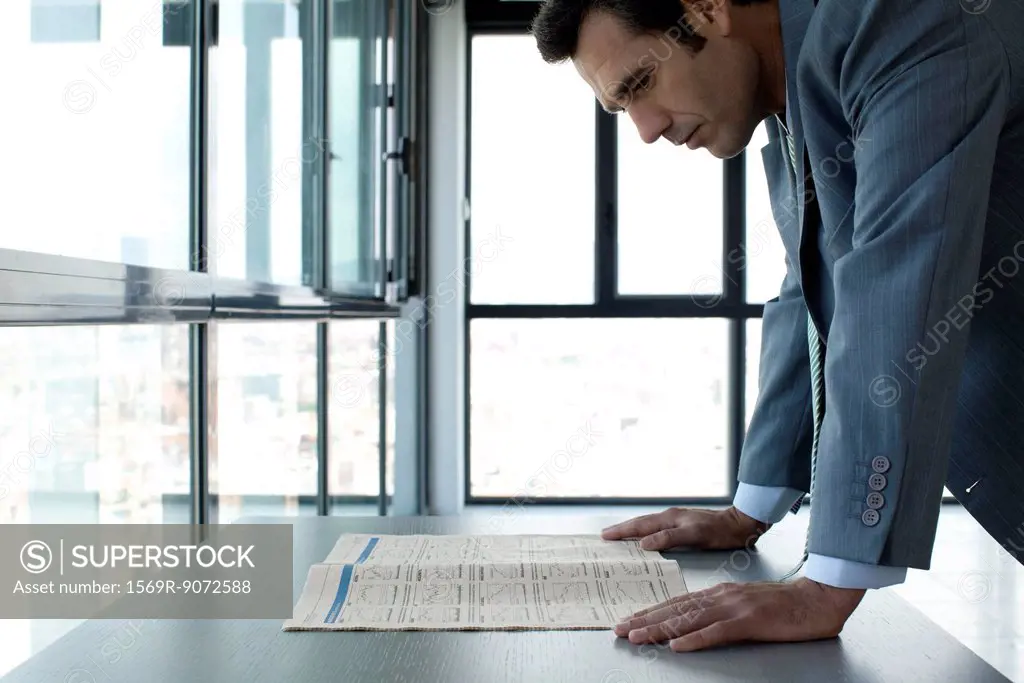 Businessman reading finance section of newspaper