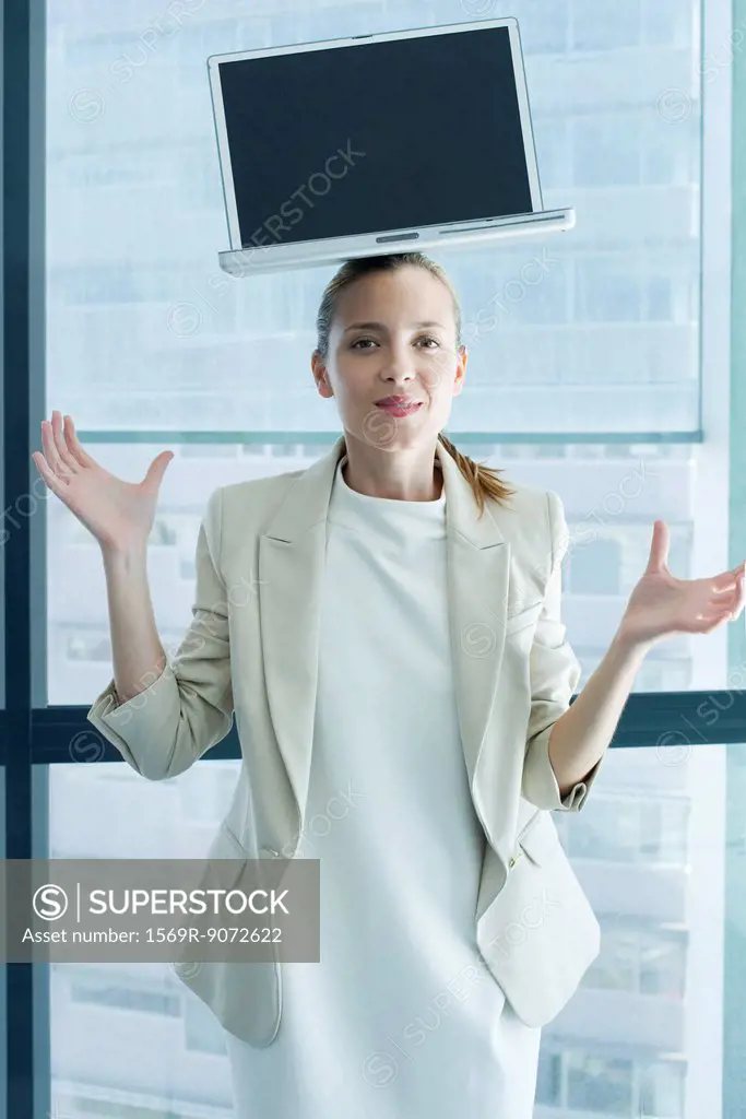 Businesswoman with laptop computer on head
