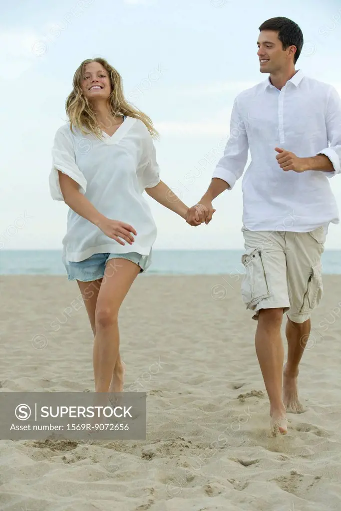 Couple walking hand in hand at the beach