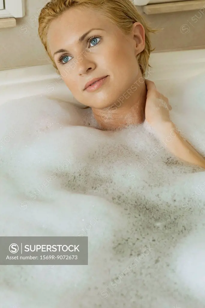 Mid_adult woman unwinding in bubble bath, portrait