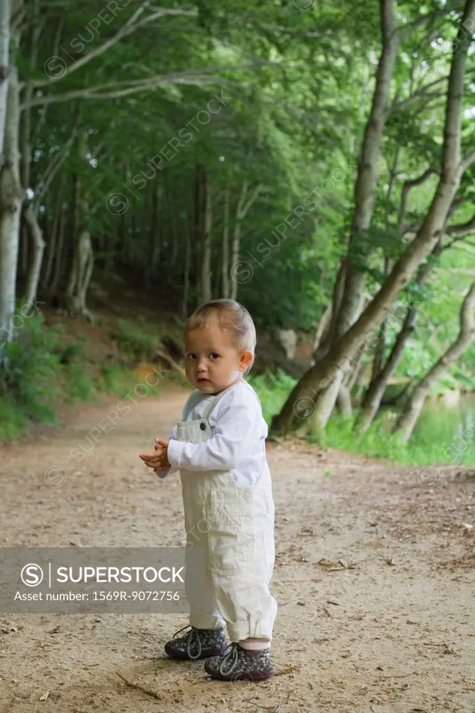 Baby girl standing in woods