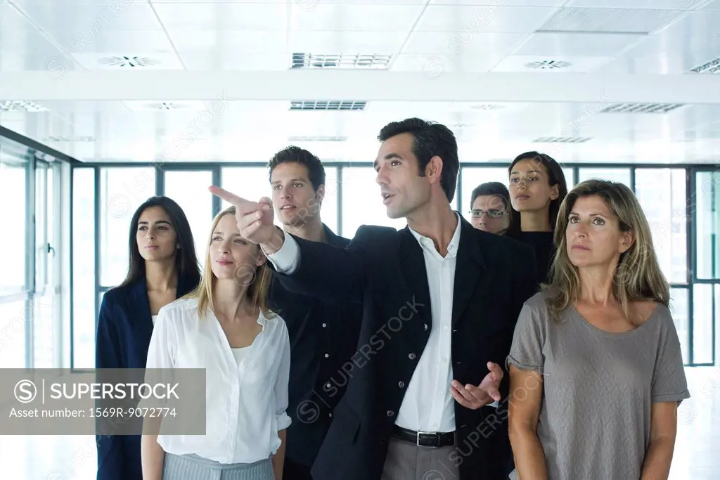 Real estate agent giving tour to business people in new office