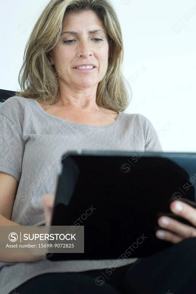 Woman using digital tablet, low angle view