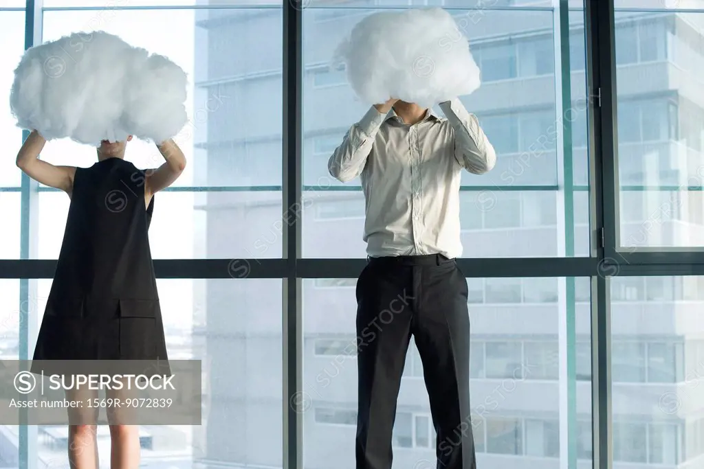 Businessman and businesswoman hiding behind clouds