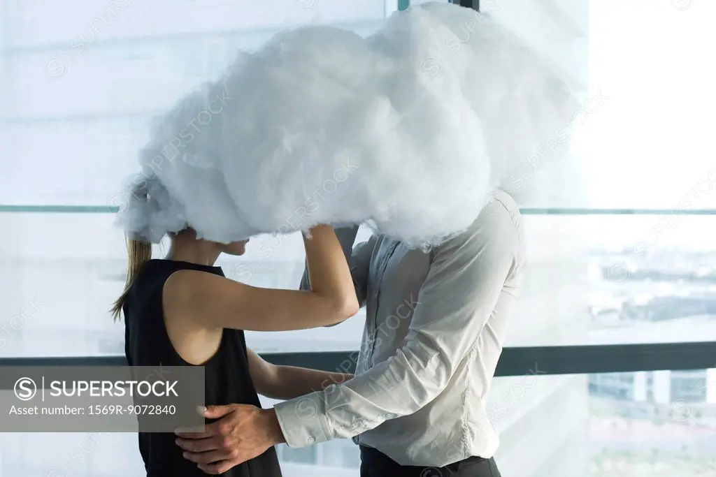 Businessman and businesswoman embracing behind cloud