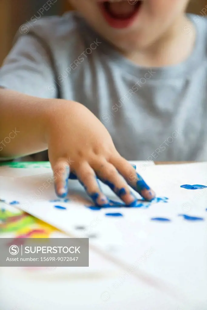 Child finger painting, cropped