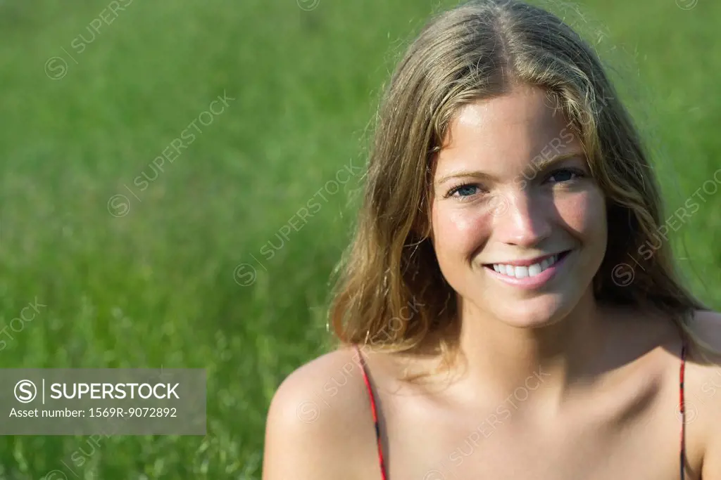 Young woman smiling outdoors, portrait