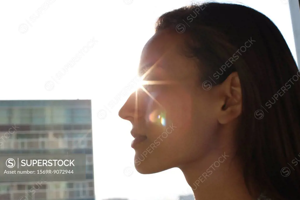 Silhouette of woman´s face, sun shinning in background