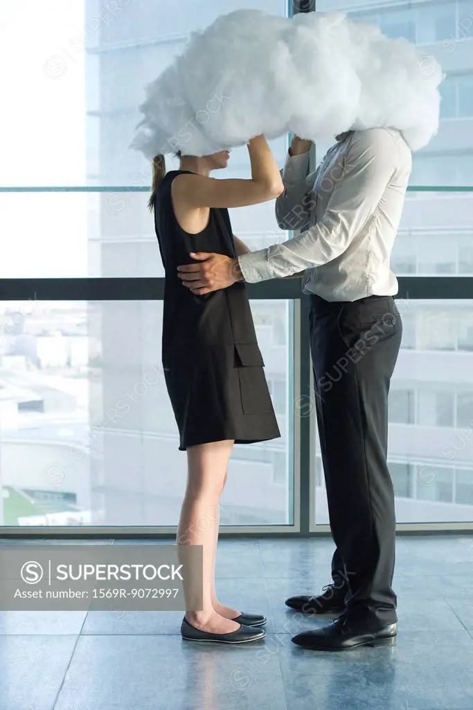 Businessman and businesswoman embracing behind cloud