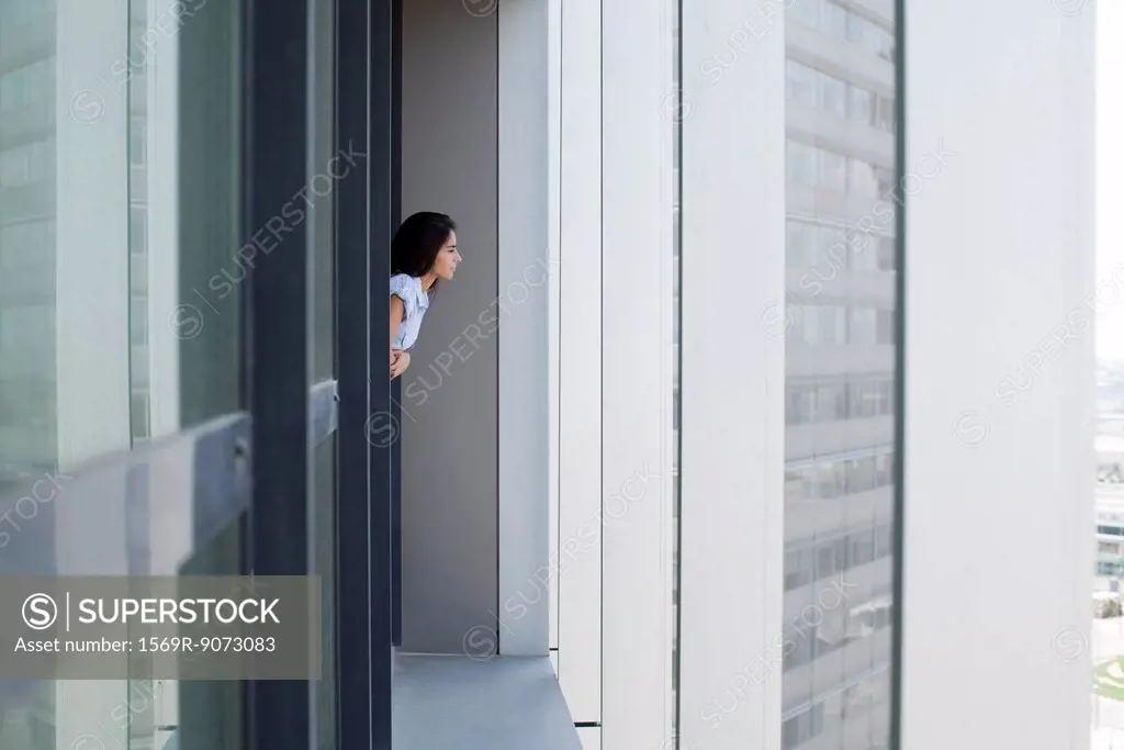 Woman leaning out of window looking at view