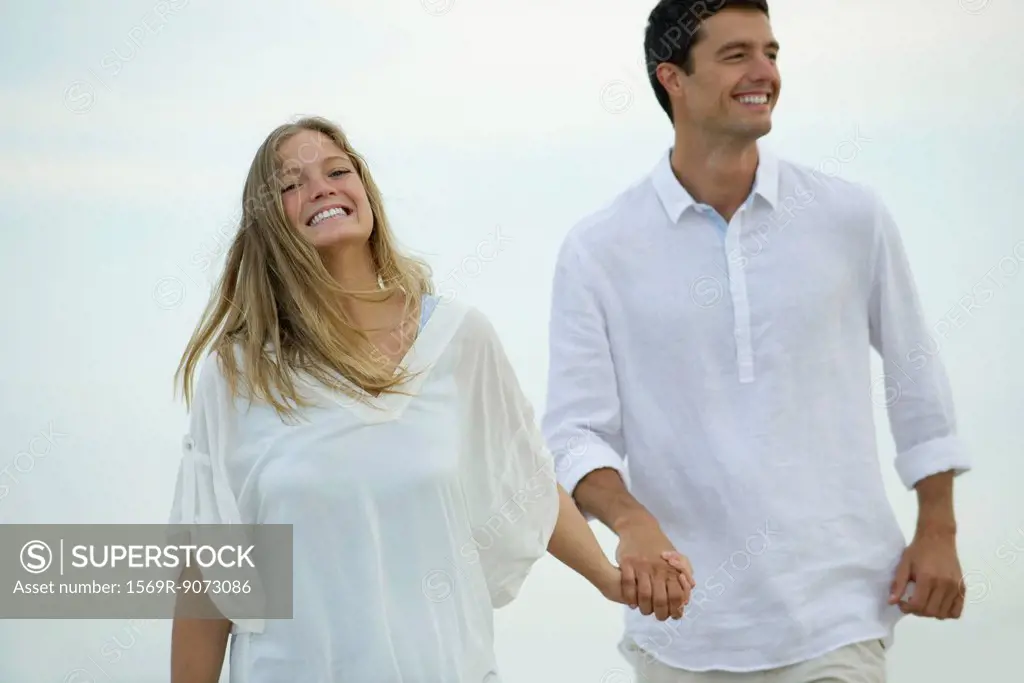 Couple walking hand in hand outdoors