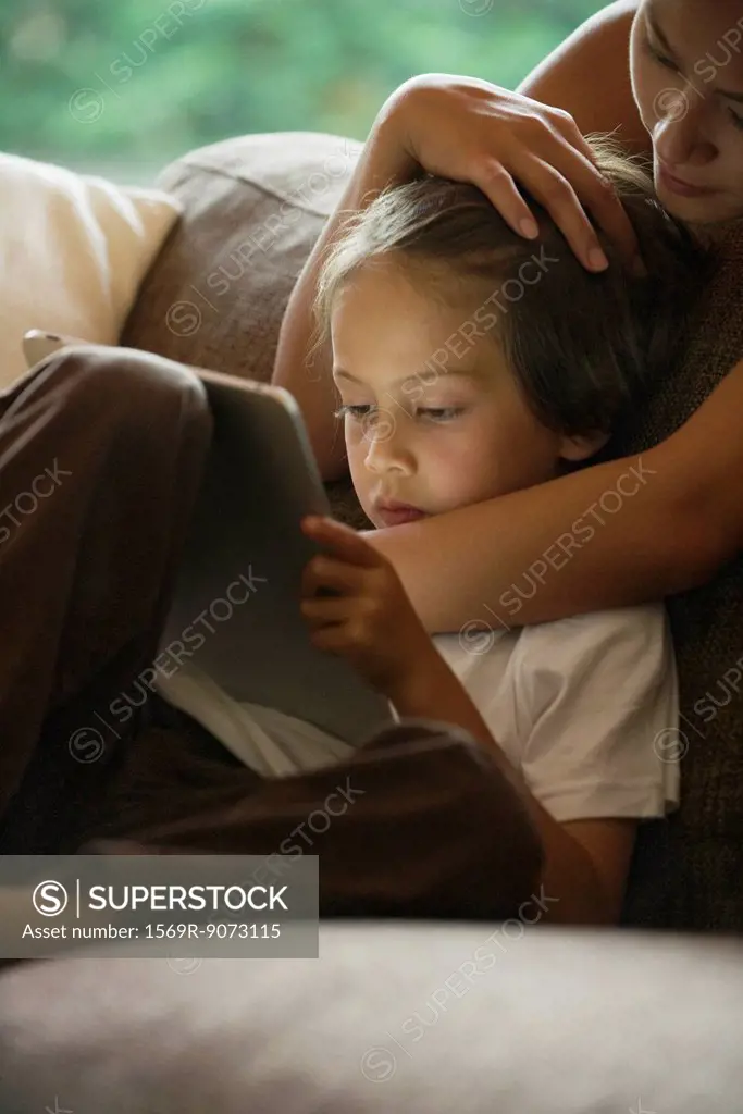 Boy and his mother looking at digital tablet