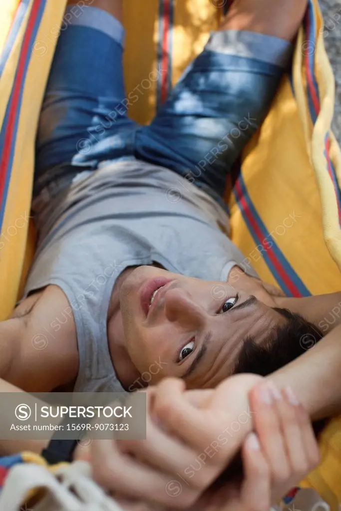 Man relaxing in hammock, portrait