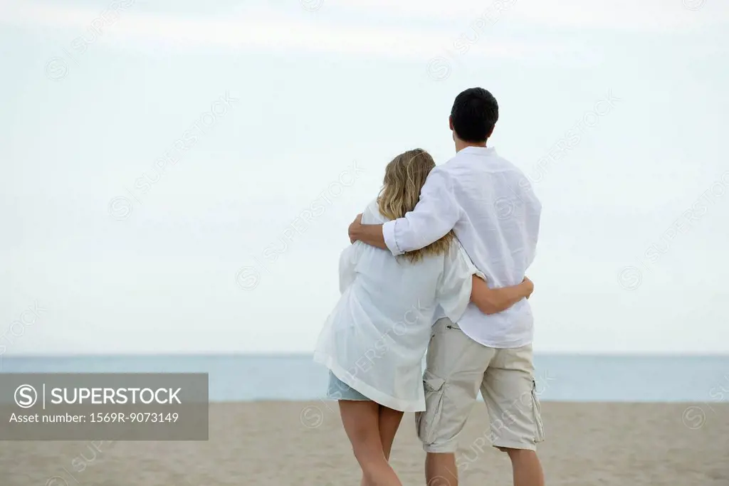 Couple walking together at the beach, rear view