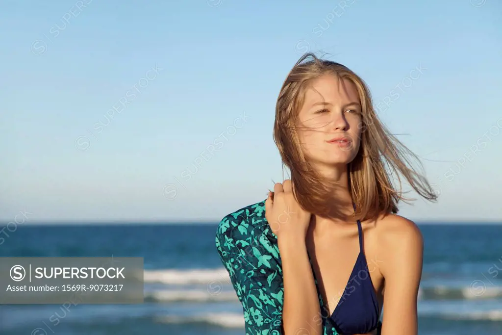 Young woman in bikini by ocean, portrait