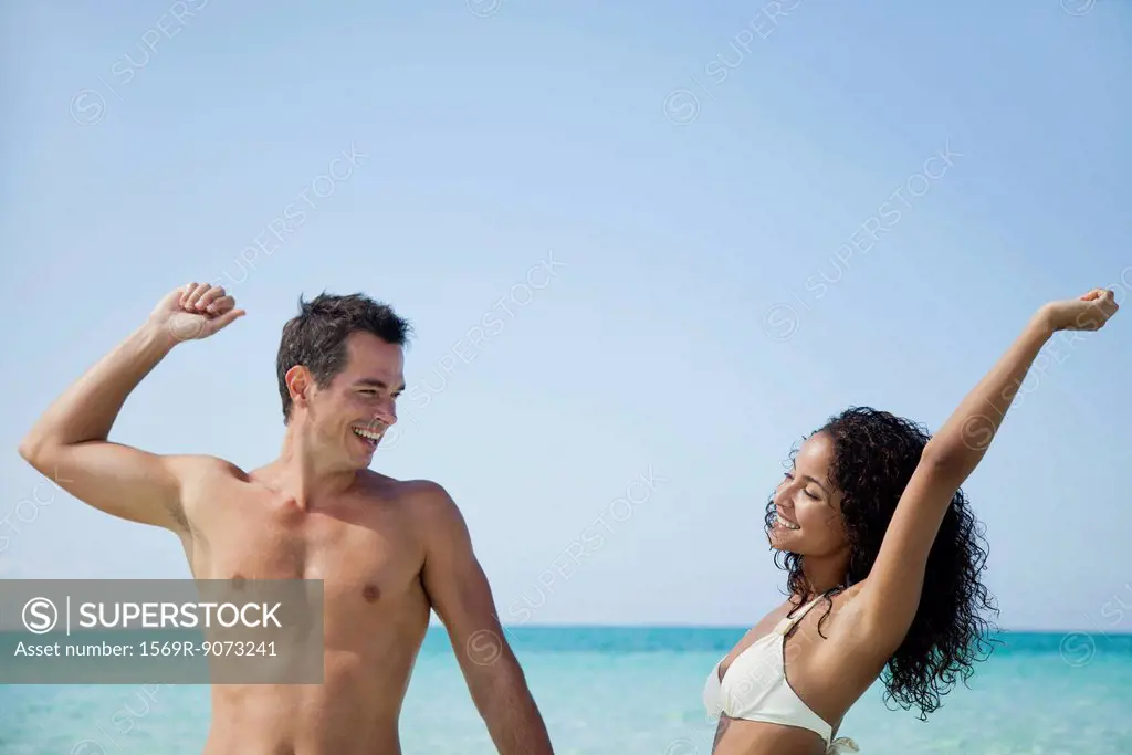 Couple stretching together at the beach