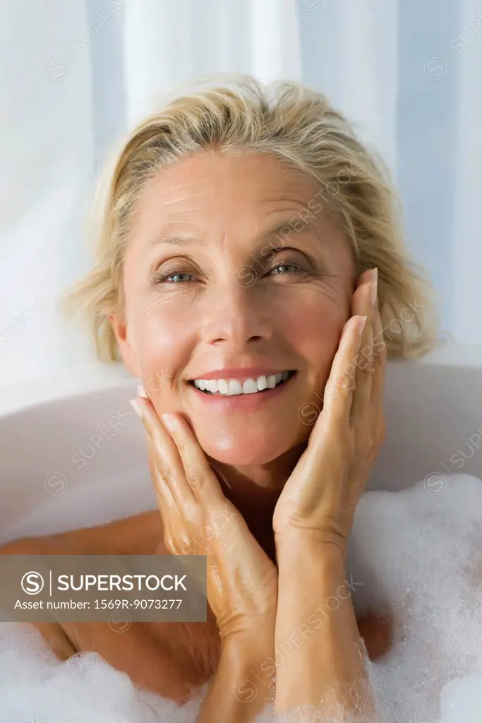 Mature woman enjoying bubble bath, portrait