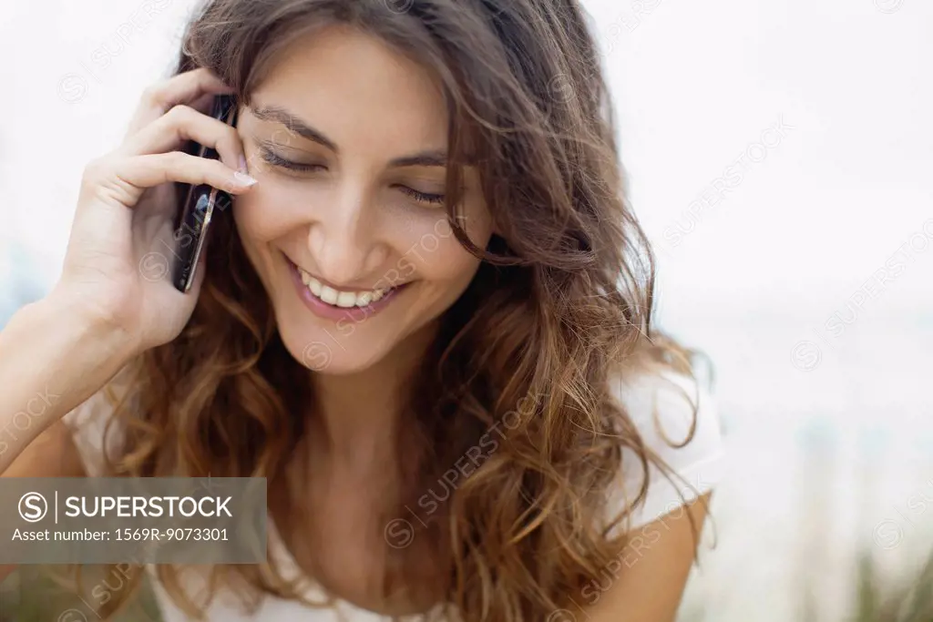 Smiling young woman talking on cell phone