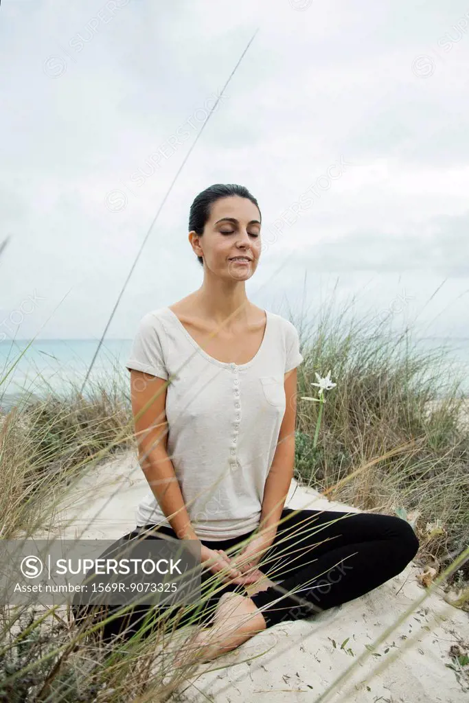 Mature woman meditating on beach, portrait