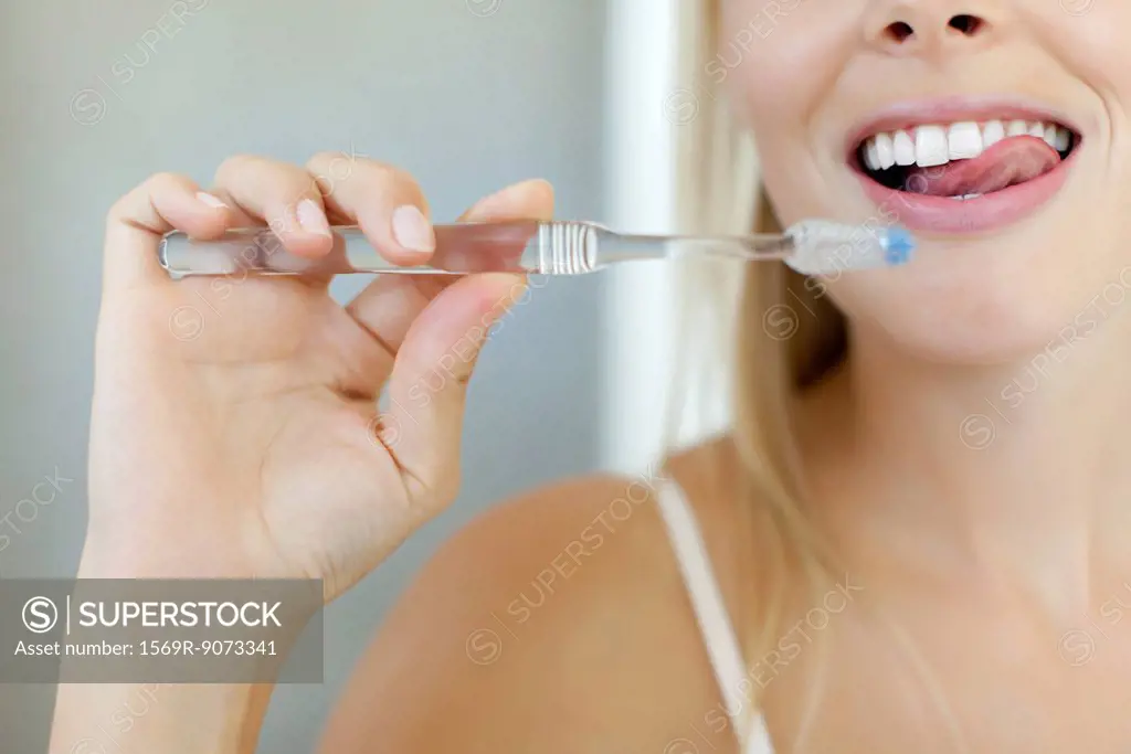 Woman brushing teeth, cropped