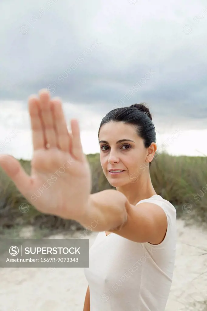 Mature woman holding up hand, selective focus