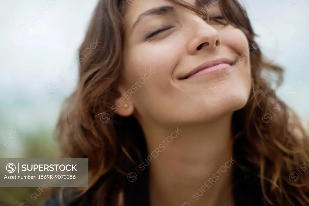 Smiling young woman with eyes closed
