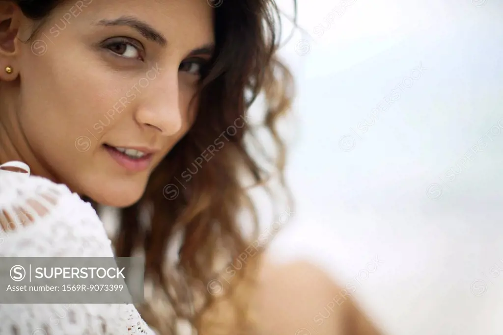 Young woman looking over shoulder, cropped